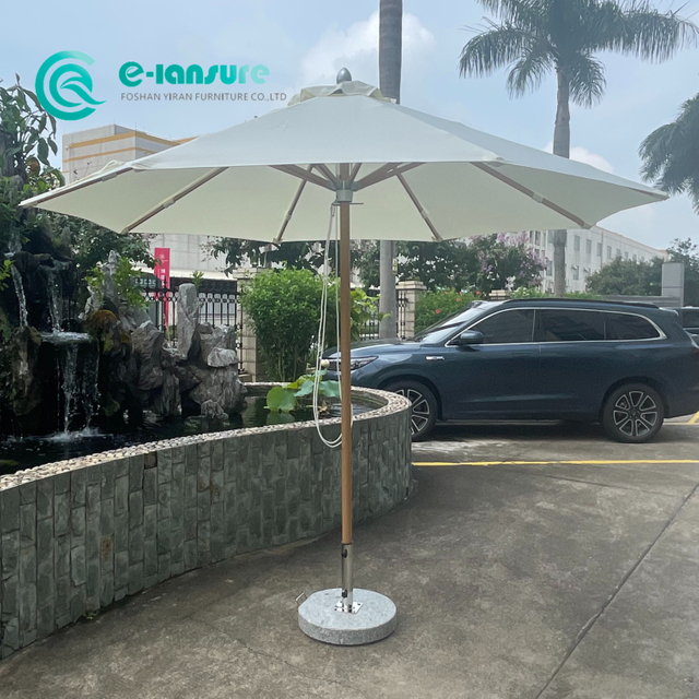 現代の卸売ガーデンパラソルアルミフレーム木製仕上げ全天候型生地パティオパラソル大理石ベース付きホテルリゾートビーチ用